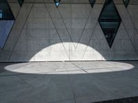 a close up of a building that's on the ground outside of it are multiple triangles of light reflected on the wall