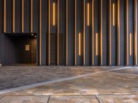 a walkway leading up to a wooden wall next to a cement area with floor tiles