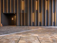 a walkway leading up to a wooden wall next to a cement area with floor tiles