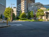 an empty road with a street sign at the curb in front of an office building