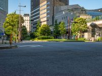 an empty road with a street sign at the curb in front of an office building