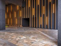 a walkway leading up to a wooden wall next to a cement area with floor tiles