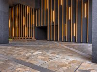 a walkway leading up to a wooden wall next to a cement area with floor tiles