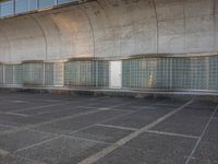 two empty parking spaces with two empty doors and a large window on the wall between two buildings