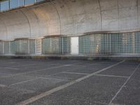 two empty parking spaces with two empty doors and a large window on the wall between two buildings