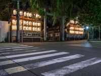 a street with several rows of lamps on either side of the road, two people crossing over a street