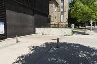 a street with a fenced off sign and a building in the background with trees in front of it