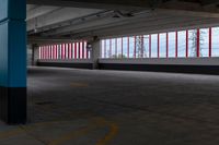 an empty parking lot with colorful stripes on the wall and ceiling and door to another