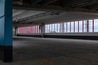 an empty parking lot with colorful stripes on the wall and ceiling and door to another