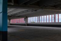 an empty parking lot with colorful stripes on the wall and ceiling and door to another