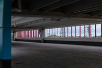 an empty parking lot with colorful stripes on the wall and ceiling and door to another