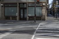 a couple of people riding on a sidewalk next to a building with windows and traffic lights