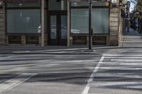 a couple of people riding on a sidewalk next to a building with windows and traffic lights