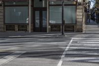 a couple of people riding on a sidewalk next to a building with windows and traffic lights