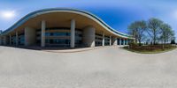 a panoramic view of an office building from the bottom up on a paved area