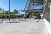 an empty parking lot with a basketball hoop and benches at the edge of the walkway