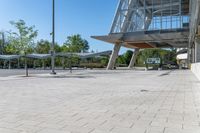 an empty parking lot with a basketball hoop and benches at the edge of the walkway