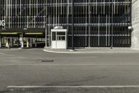 a black parking meter and car wash sign on a sidewalk outside a building with lots of windows