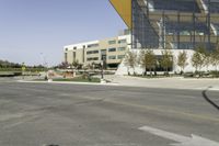 an empty street with a bus stop sign on it in front of a building,