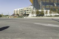 an empty street with a bus stop sign on it in front of a building,