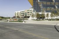 an empty street with a bus stop sign on it in front of a building,