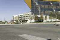 an empty street with a bus stop sign on it in front of a building,