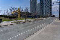 an empty street with several buildings along side of it on either side are bushes and shrubs