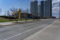 an empty street with several buildings along side of it on either side are bushes and shrubs