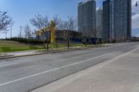 an empty street with several buildings along side of it on either side are bushes and shrubs