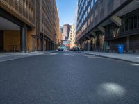 a road through which is a large modern building with an awning over it's entrance