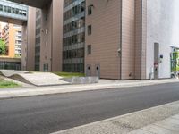 the empty sidewalk on the side of the street near the building in the city is cobblestone