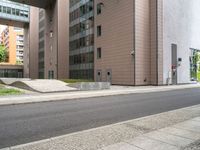 the empty sidewalk on the side of the street near the building in the city is cobblestone