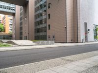 the empty sidewalk on the side of the street near the building in the city is cobblestone