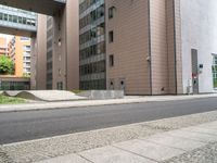 the empty sidewalk on the side of the street near the building in the city is cobblestone