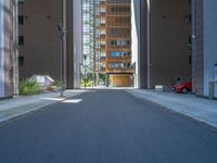 a road through which is a large modern building with an awning over it's entrance