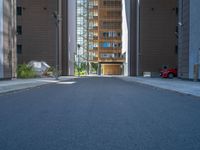 a road through which is a large modern building with an awning over it's entrance