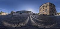 a panorama photo of a street with a building and sky in the background to see