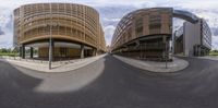 a curved circular building sits near the roadway and traffic lanes on a road in the city