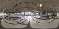 a reflection image on the floor in an indoor gym area with a roof and circular stairs