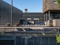 the front of a building with a metal fence and several pots on top of it