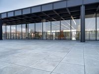 the exterior of a modern building with glass walls and a concrete slab floor below it
