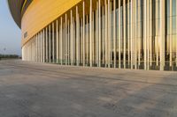 a building with many windows and a concrete slabing on the ground outside and sidewalk