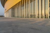 a building with many windows and a concrete slabing on the ground outside and sidewalk