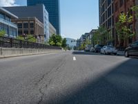 an empty street with buildings and parked cars on the sidewalks and green lanes on the sidewalk