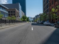 an empty street with buildings and parked cars on the sidewalks and green lanes on the sidewalk