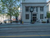 an empty street with buildings and parked cars on the sidewalks and green lanes on the sidewalk