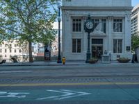 an empty street with buildings and parked cars on the sidewalks and green lanes on the sidewalk