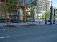 an empty street with buildings and parked cars on the sidewalks and green lanes on the sidewalk