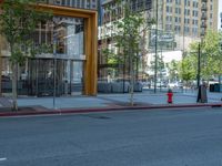 an empty street with buildings and parked cars on the sidewalks and green lanes on the sidewalk