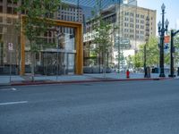 an empty street with buildings and parked cars on the sidewalks and green lanes on the sidewalk